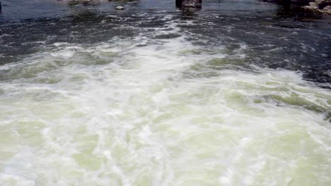 mirando hacia abajo sobre el agua turbulenta que sale de una presa en las esclusas del ascensor kawartha buckhorn en ontario, canadá