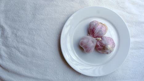 garlic on white ceramic plate on white table mat