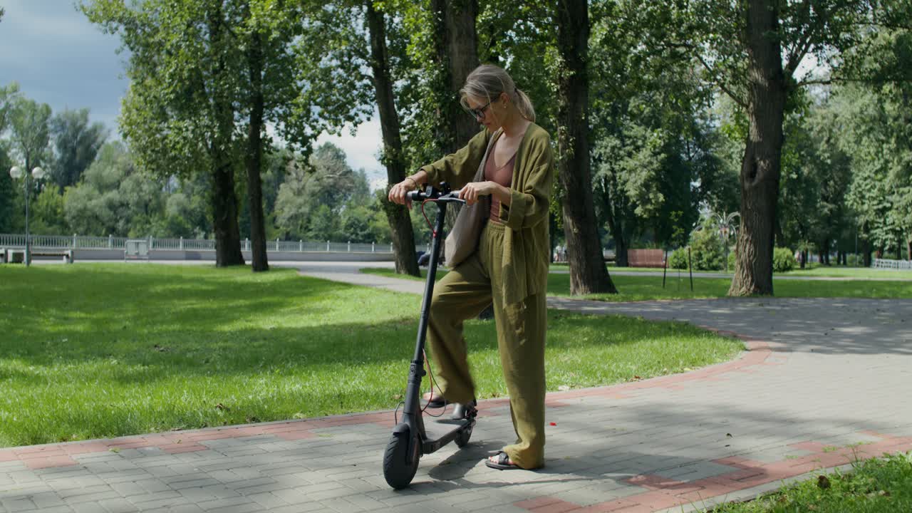 Parkta elektrikli scooter kullanan kadın
