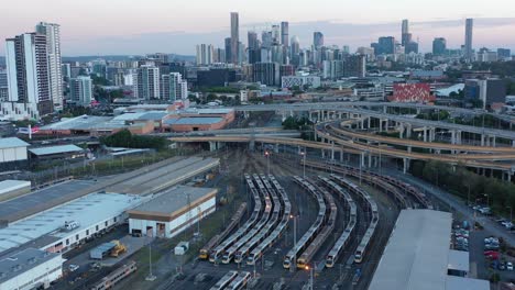 Drone-shot-of-train-yard-in-Brisbane,-with-ICB-and-Brisbane-CBD-visible-in-foreground