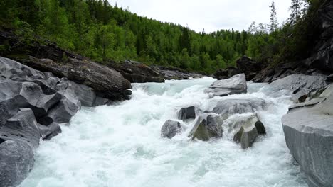 Wide-shot-of-Marmorslottet,-Norway-with-water-running-in-the-river