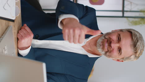 hombre de negocios feliz mirando con aprobación a la cámara mostrando los pulgares hacia arriba, como un signo positivo, buenas noticias