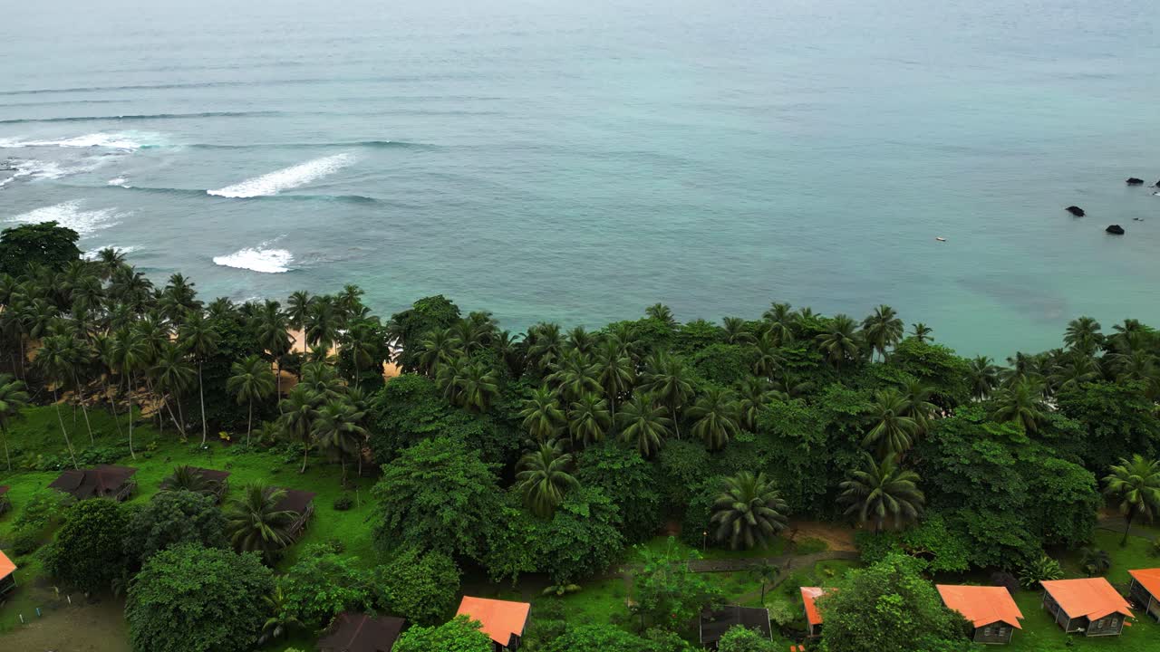 Aerial view over the Inhame village, revealing the Rolas island in cloudy Sao Tome