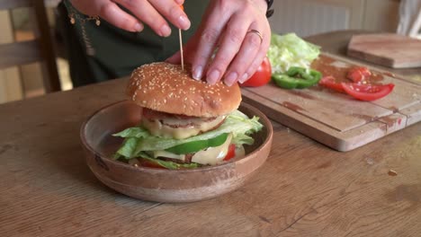 cook finishing preparing a delicious vegan burger with veggie in 4k slow motion