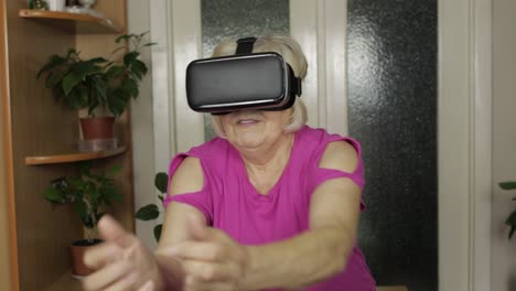 Abuela-Mayor-Con-Gafas-Virtuales-Viendo-Vídeos-En-3d-En-Un-Casco-De-360-Vr-En-Casa