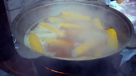 corn boiled in pan. street food. cooking sweet corn in boiled water