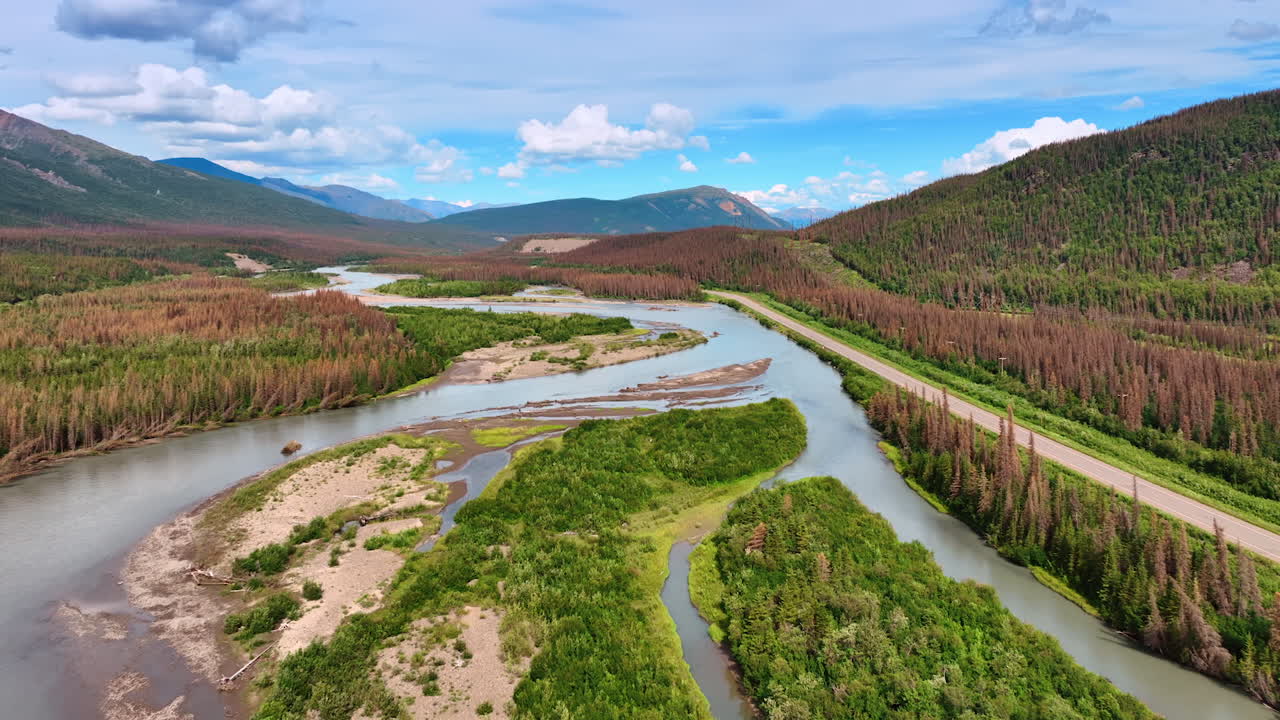 Majestic landscapes along Alaskan rivers. Winding rivers flow through Alaska's stunning terrain, revealing vibrant greenery and rugged hills under a clear sky