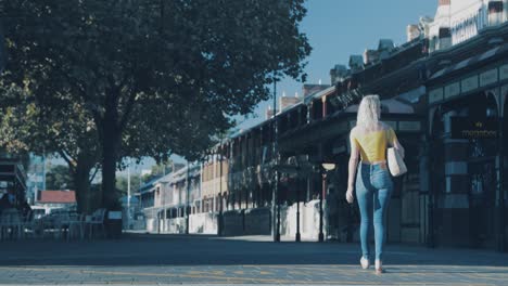 Woman-walking-over-road,-car-goes-past