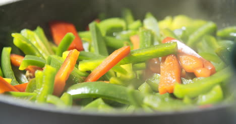 mixing fresh vegetables on pan