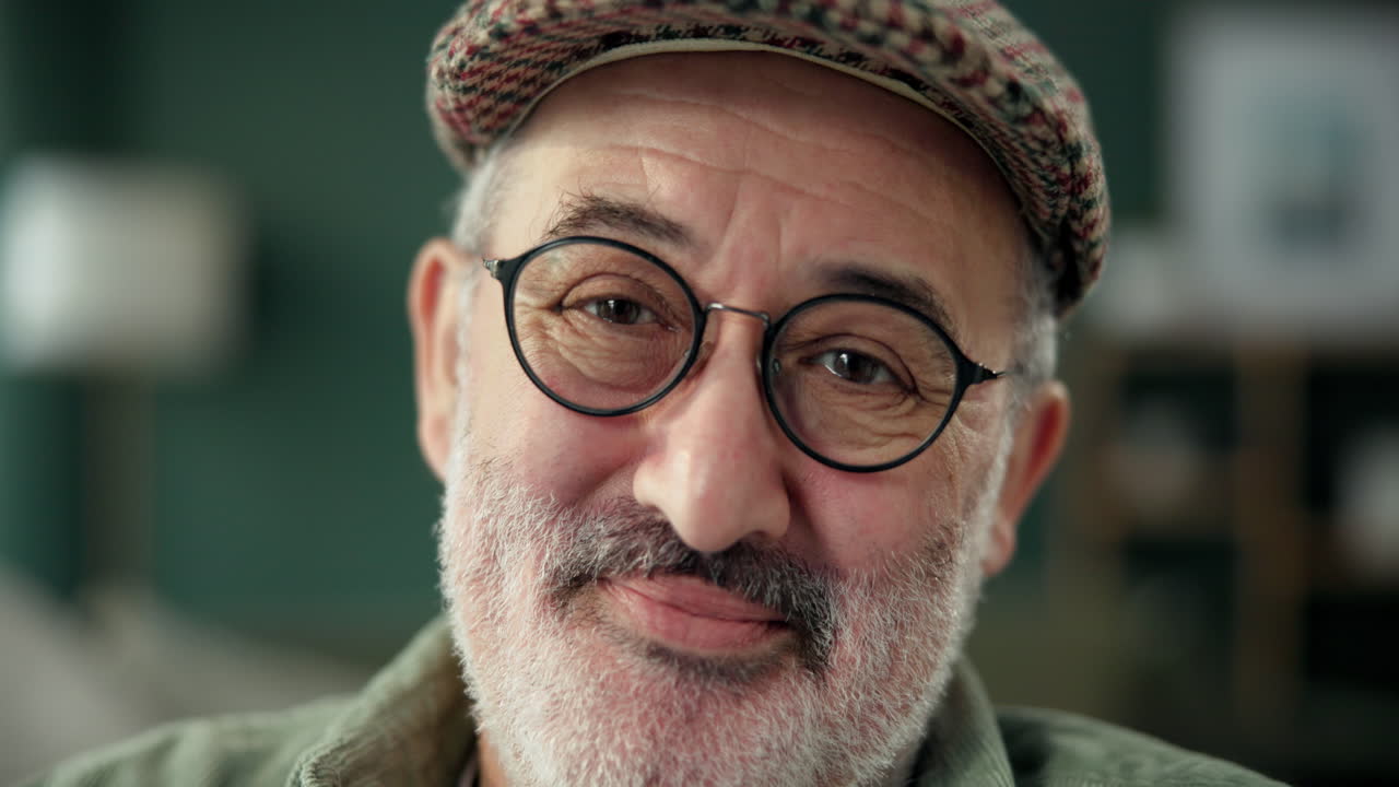 Portrait of an elderly man with glasses and a hat