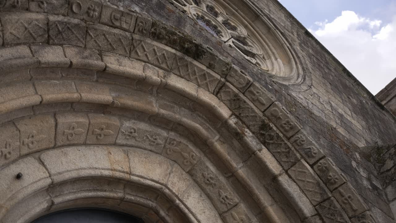 Close up of ancient carved stone arch with symbols on medieval church facade in Portugal
