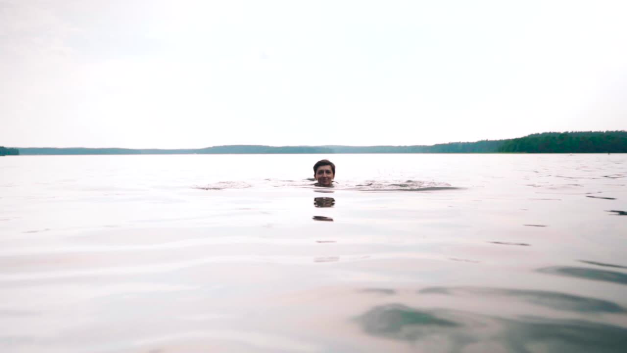 chica nadando bajo el agua en un lago, olas suaves y ondas en la superficie del agua