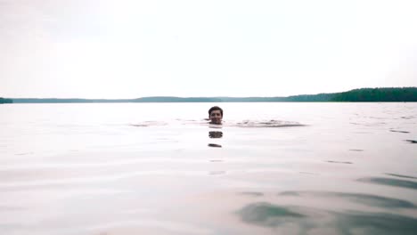 Chica-Nadando-Bajo-El-Agua-En-Un-Lago,-Olas-Suaves-Y-Ondas-En-La-Superficie-Del-Agua