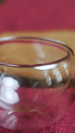pouring tea into a double-walled glass cup