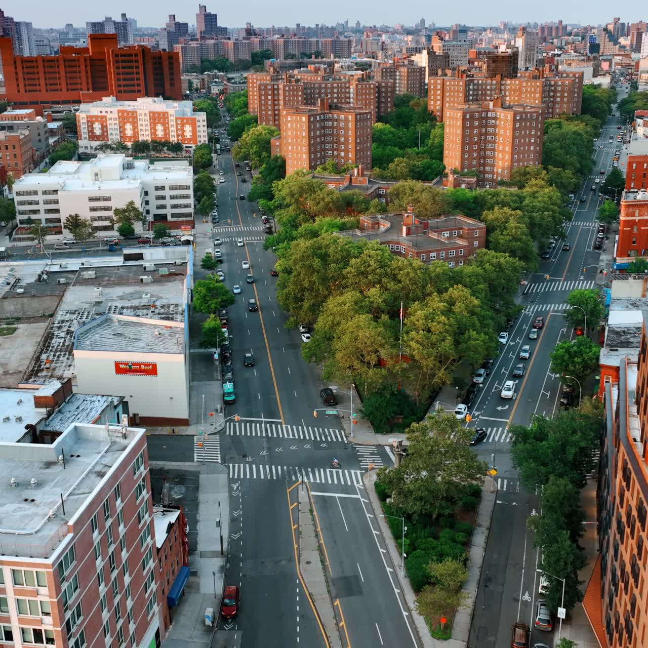 Two highways merge into one. Busy roads around the green residential area. New York cityscape from top view