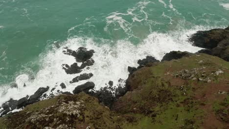 aerial tilt up from the crashing waves at land's ends to the open atlantic ocean