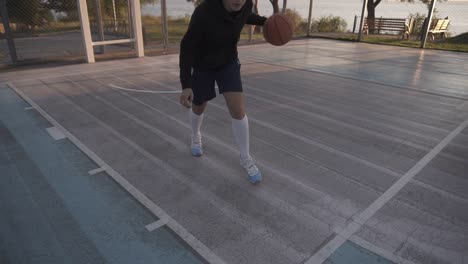 Basketballspielerin-Im-Morgenlicht-Auf-Dem-Profiplatz,-Der-Mit-Ball-1-Läuft
