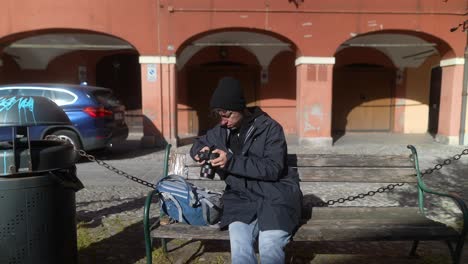 teenager taking photos on a bench in a european city