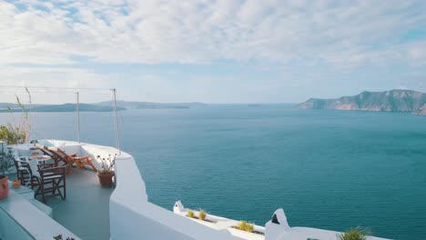 Weiße-Terrasse-Mit-Stühlen-Und-Blick-Auf-Die-Caldera-In-Oia,-Santorini