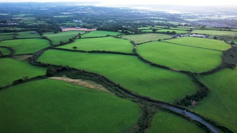 AERIAL:-Fly-across-lush-green-farmer's-fields,-Gower,-4k-Drone