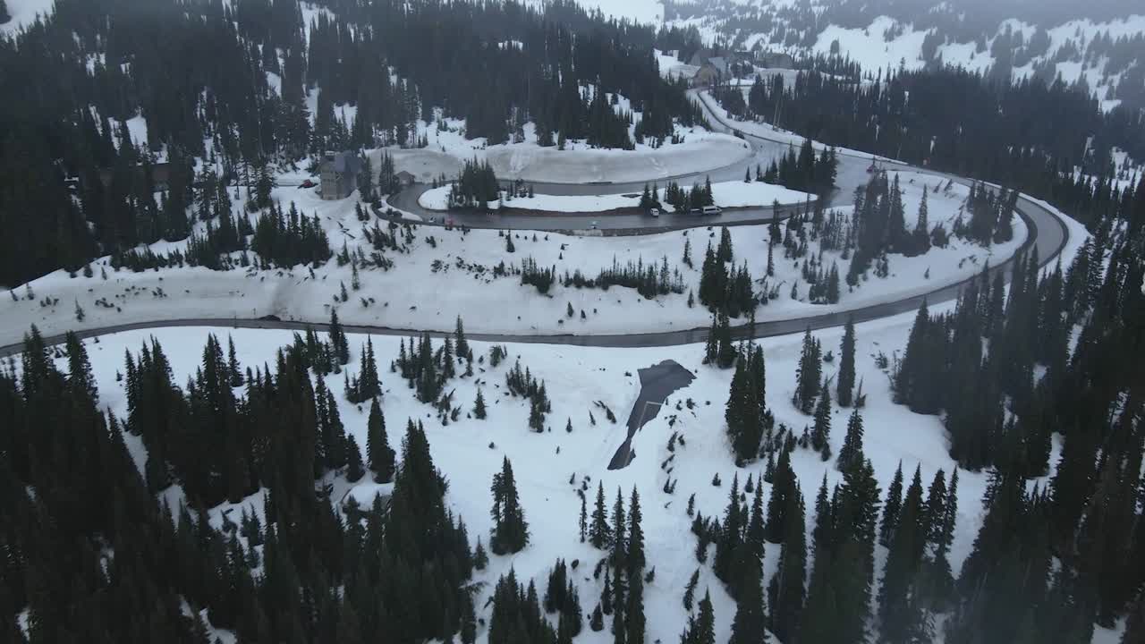Aerial drone shot flying over the snowy mountains of Mount Rainier during winter, showcasing a vast white landscape
