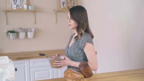 lady takes wheat grains to domestic flour mill at table