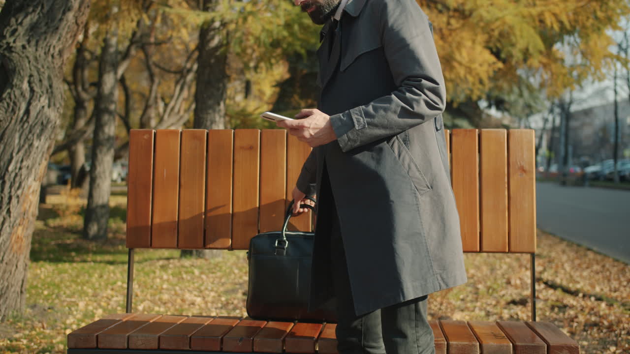 Businessman using phone in the park