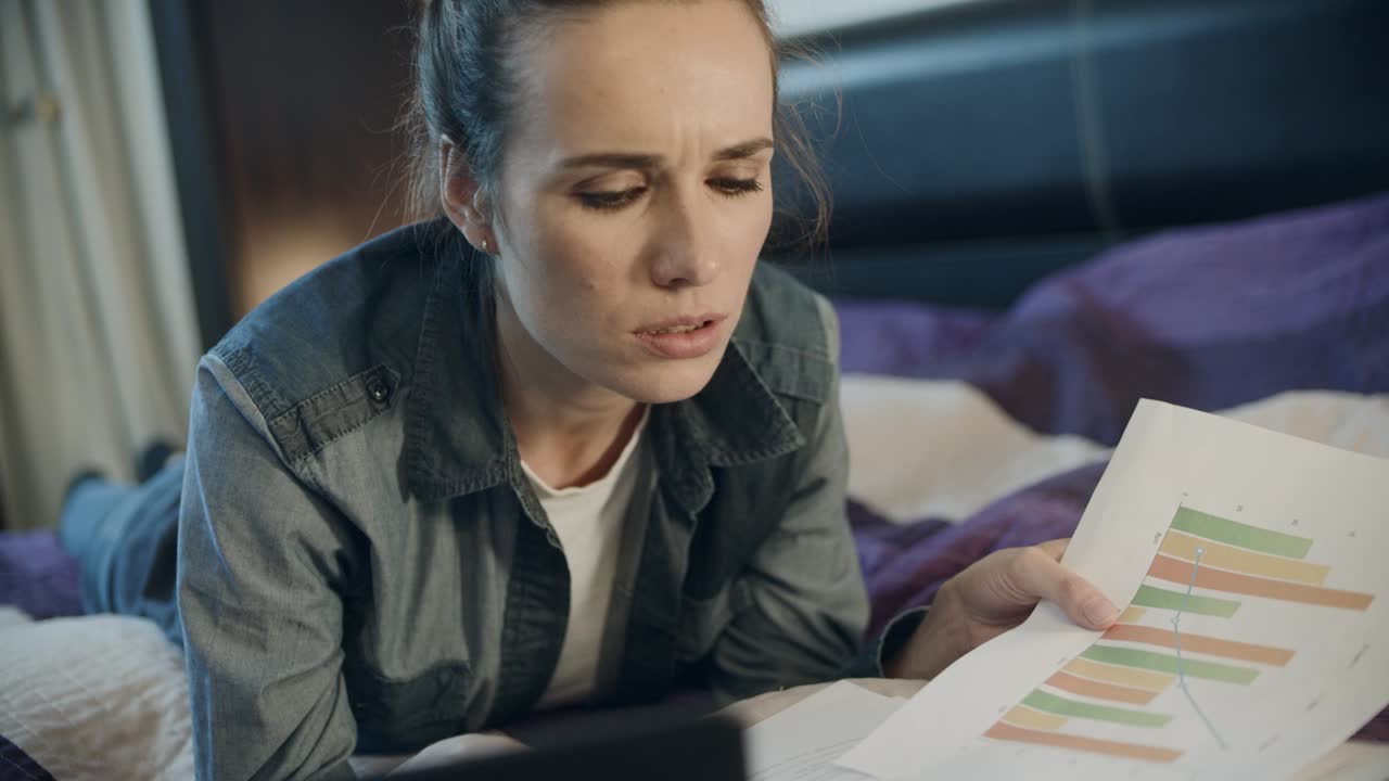 Empresária olhando documentos no sofá. Empreendedora contabilizando o lucro