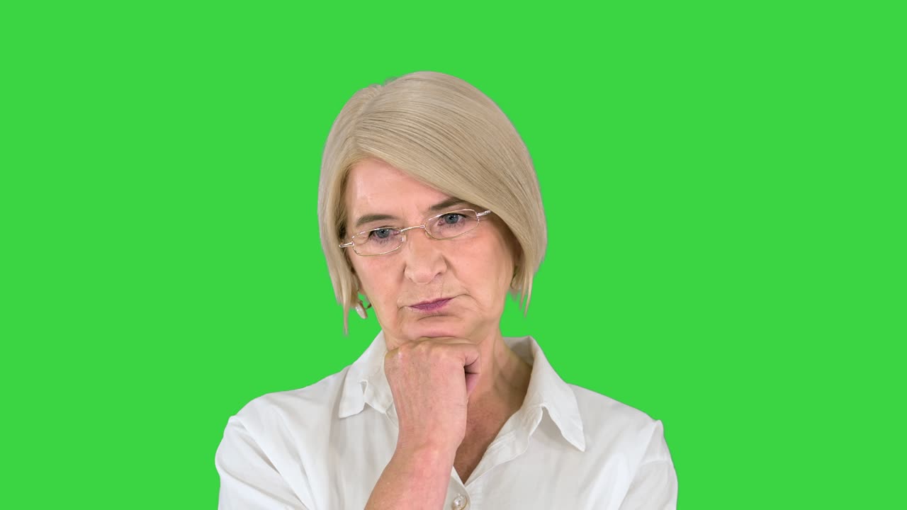 Aged woman thinking and having an idea pointing finger up on a Green Screen, Chroma Key