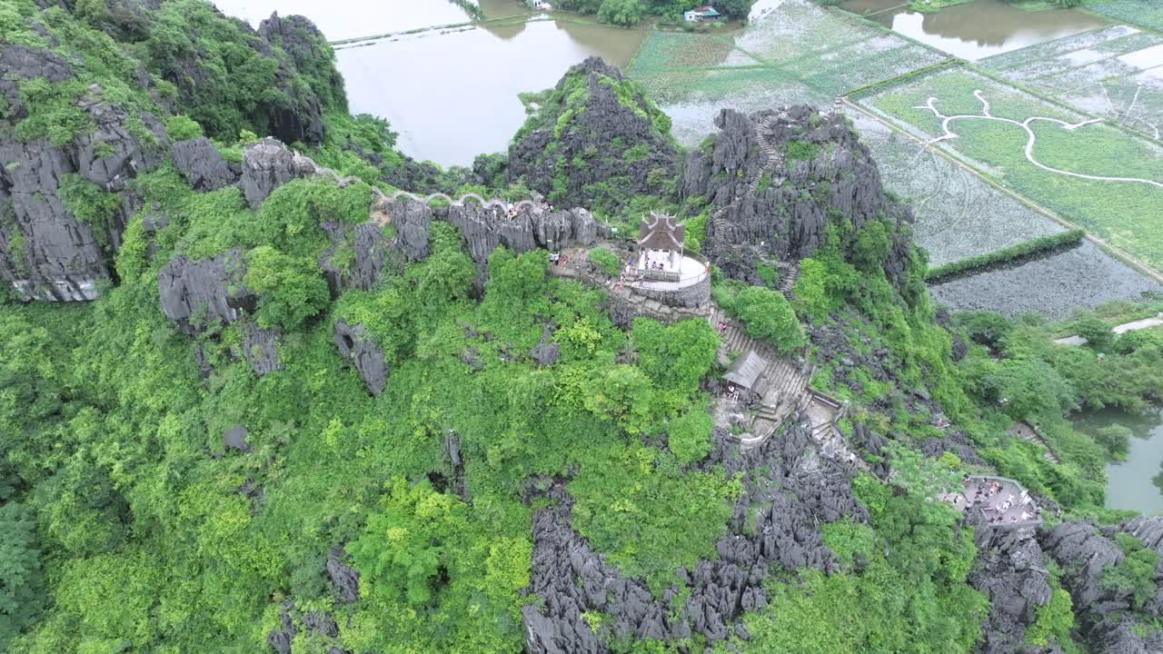 Temple path winding over limestone mountains in Ninh Binh, Vietnam from above