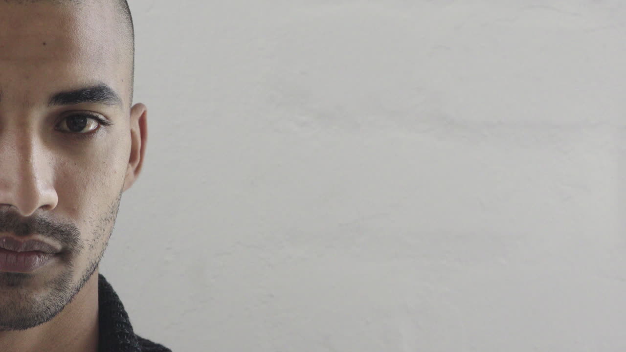 cerca un joven hispano atractivo mirando hacia arriba sonriendo con confianza satisfacción sobre fondo blanco mitad de la cara