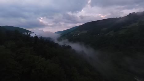 aerial view flying above lush green tropical rain forest mountain with rain cloud cover during the rainy season on the doi phuka mountain reserved national park the northern thailand