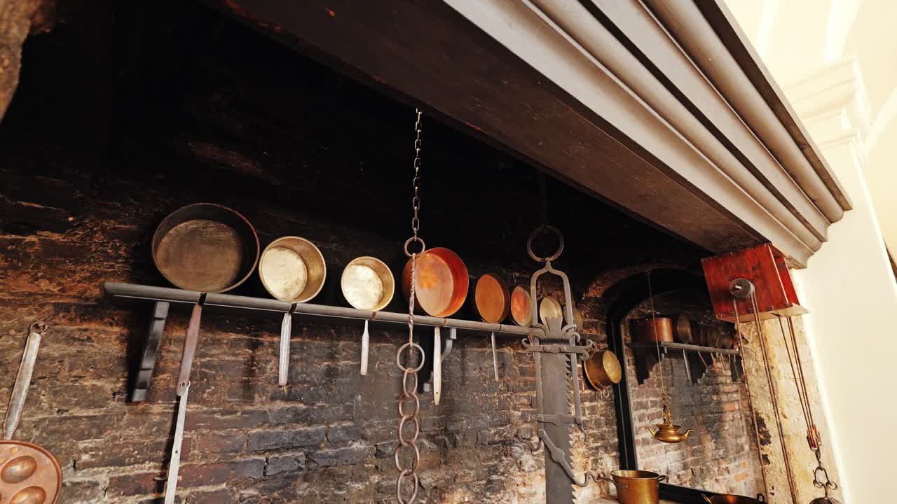 Baroque kitchen wall with aged bricks, cookware, chains, rustic fireplace frame