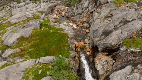 Arroyo-Que-Fluye-Sobre-Las-Montañas-Del-Cañón-Hellmo,-Tysfjord,-Norte-De-Noruega