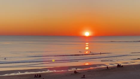 slowly waves form and break, beautiful atlantic ocean, deep yellow sunset on water reflections, portugal