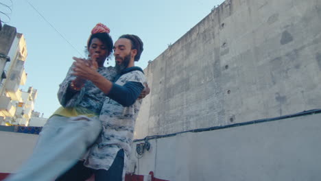 young black woman dancing tango with partner on urban rooftop