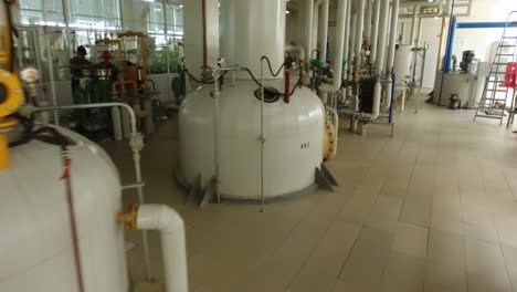 Walk-through-of-a-mechanical-room-in-a-industrial-plant-with-a-worker-walking-past-equipment