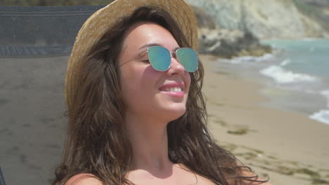 mujer sonriente relajándose en la playa
