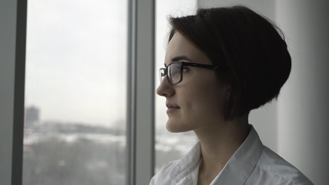 una mujer mirando por la ventana.