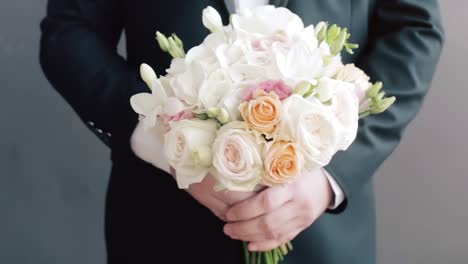 groom holding a wedding bouquet