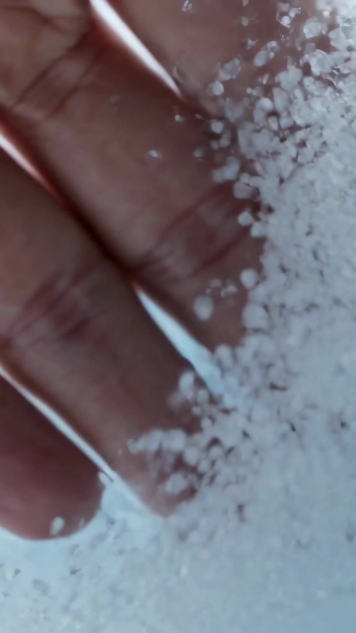 Video verticale: Mano nuda che scorre, entrando da sinistra sul vetro dell'auto, rimuovendo il ghiaccio per rivelare il cielo.