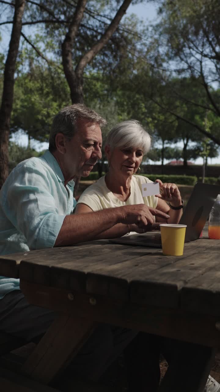 Senior Couple Enjoying Online Shopping in the Park