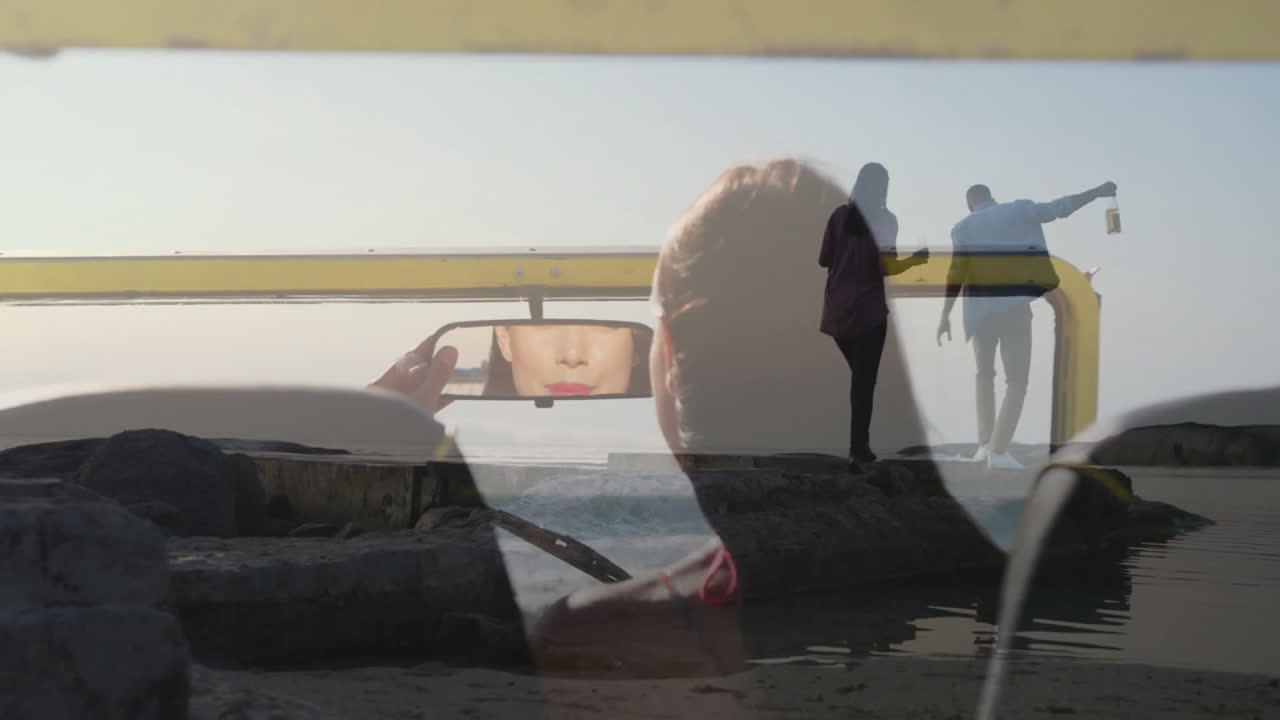 Silhouetted people by water, animation of face reflecting in rearview mirror
