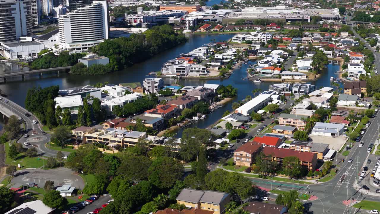 Aerial footage showcasing Gold Coast's urban environment with waterways, residential areas, and high-rise buildings under bright daylight