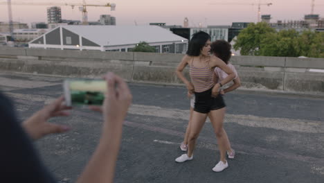 mujer bailarina feliz chicas multiétnicas realizando movimientos de estilo libre juntas amiga usando teléfono inteligente tomando video disfrutando de compartir el baile de hip hop en las redes sociales