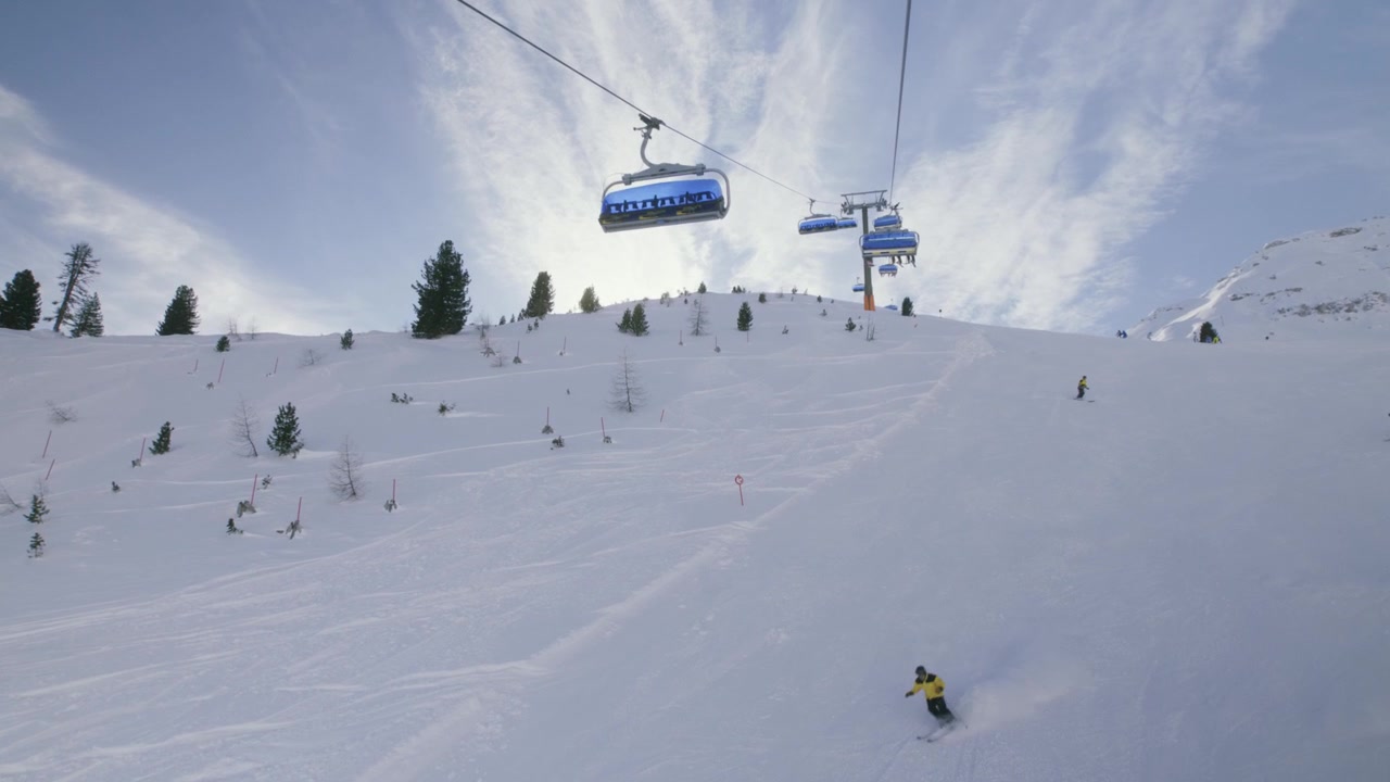 Chairlift POV of skiers in Austrian alps ski resort (Schlick 2000)