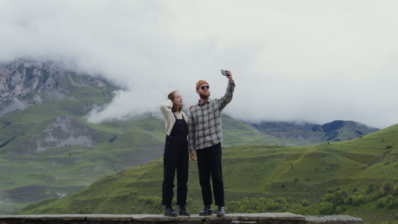 пара делает селфи в горах.