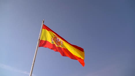 Nationalflagge-Spaniens-Weht-Bei-Windigem-Wetter-Gegen-Den-Blauen-Himmel