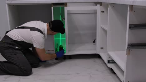 a professional master during the installation of kitchen furniture a professional master during the installation of kitchen furniture installation of modern highquality furniture accessories moving to a new apartment