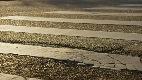 Menschen,-Die-Eine-Straße-Am-Zebrastreifen-Unter-Dem-Goldenen-Licht-Des-Sonnenuntergangs-überqueren,-Gefilmt-In-Zeitlupe-In-4k-High-Definition